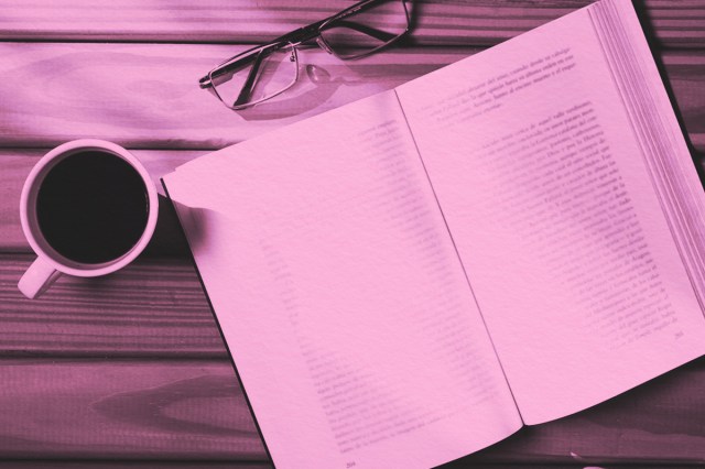 Aerial view of an open book , eyeglasses and cup of coffee