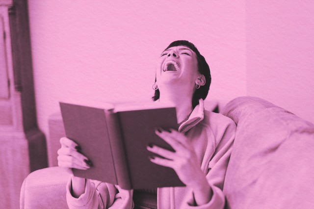 Woman Laughing While Reading Book