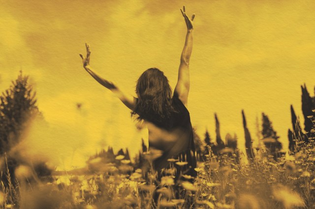 woman enjoying the sun in a flower field