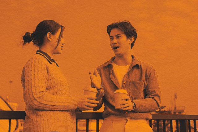 Two people engage in a conversation on a rooftop