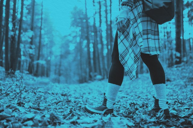 Woman's legs in boots in autumn foliage