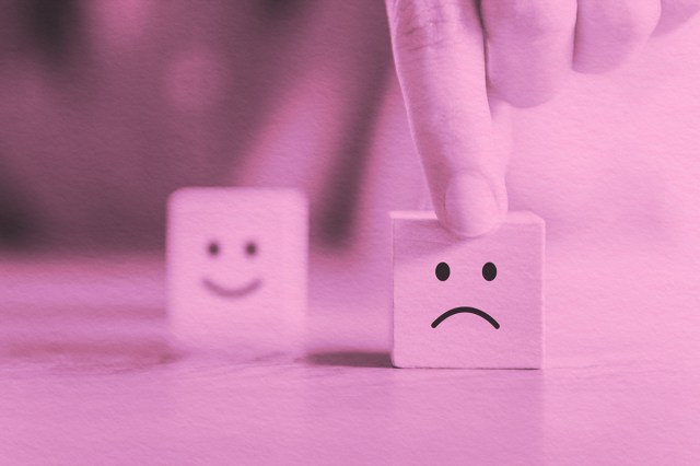 Happy face block in background, sad face block in foreground